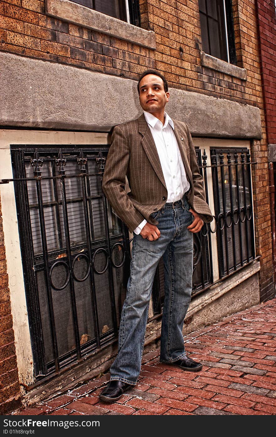 African american male posing on the sidewalk  wearing dress shirt , suit coat, blue jeans looking up street in beacon hill boston massachusetts. African american male posing on the sidewalk  wearing dress shirt , suit coat, blue jeans looking up street in beacon hill boston massachusetts