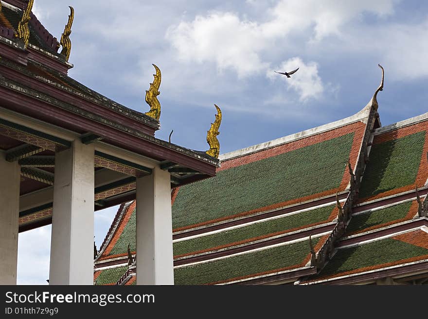 Roofs of buddhist temple with eagle flying in the background, bangkok, thailand. Roofs of buddhist temple with eagle flying in the background, bangkok, thailand.