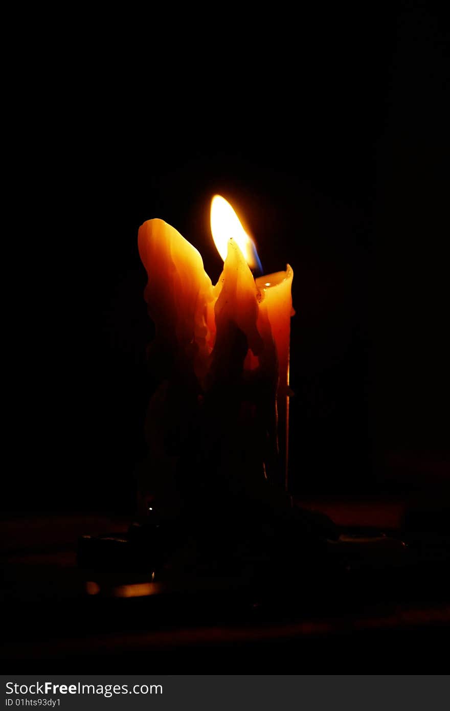 View of a melted candle on low light conditions. View of a melted candle on low light conditions.