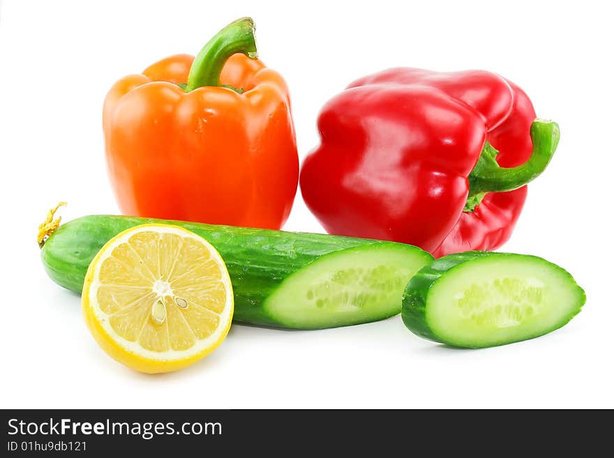 Fresh vegetables fruits (paprika, cucumber and lemon) isolated on a white background. Shot in a studio. Fresh vegetables fruits (paprika, cucumber and lemon) isolated on a white background. Shot in a studio.