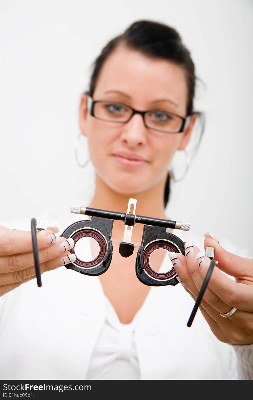 Beautiful young doctor in white cape and ophthalmological equipment