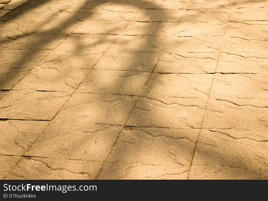 Dappled light on stone texture of path or sidewalk suitable for spring or summer background