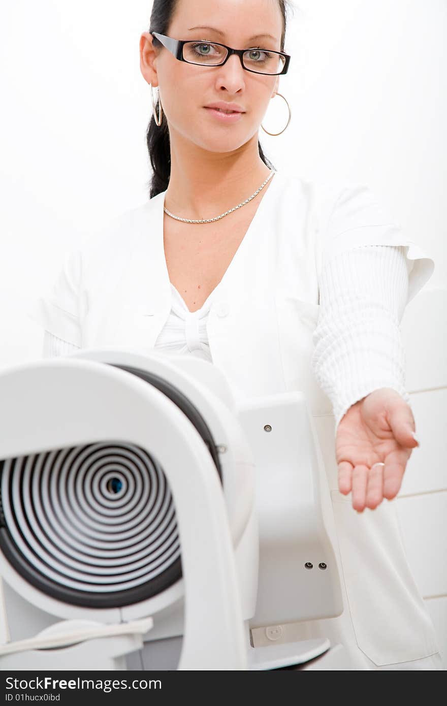 Beautiful young doctor in white cape and ophthalmological equipment