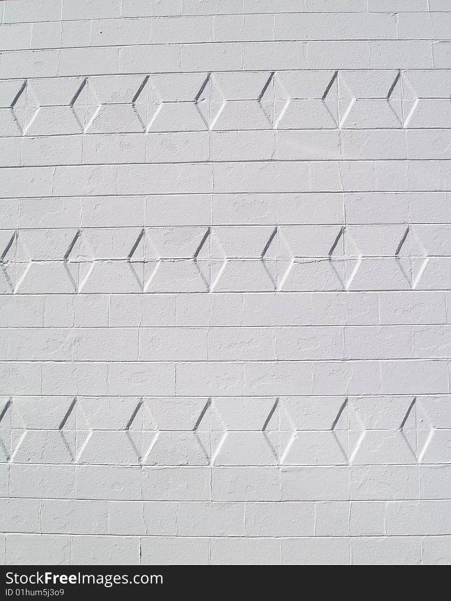 White painted brick or block exterior wall with diamond texture. White painted brick or block exterior wall with diamond texture.