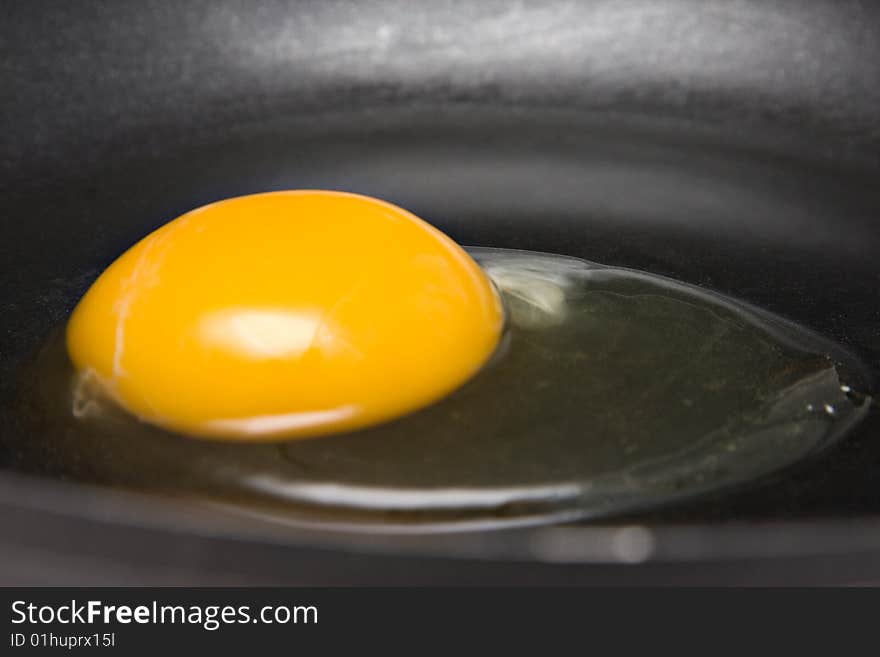 A raw egg in a nonstick frying pan. A raw egg in a nonstick frying pan.