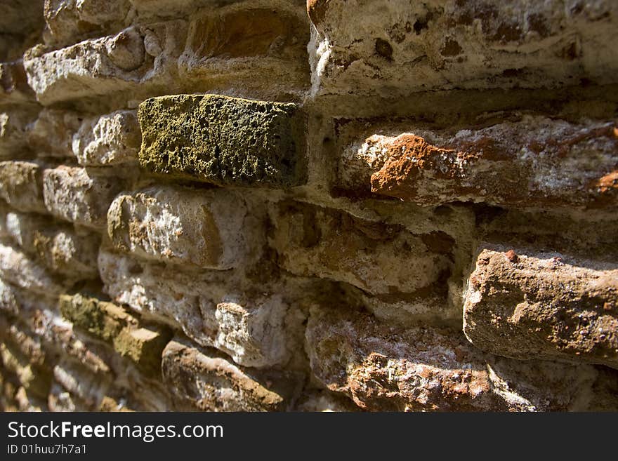 One green brick draws focus in a wall of red and white bricks. One green brick draws focus in a wall of red and white bricks