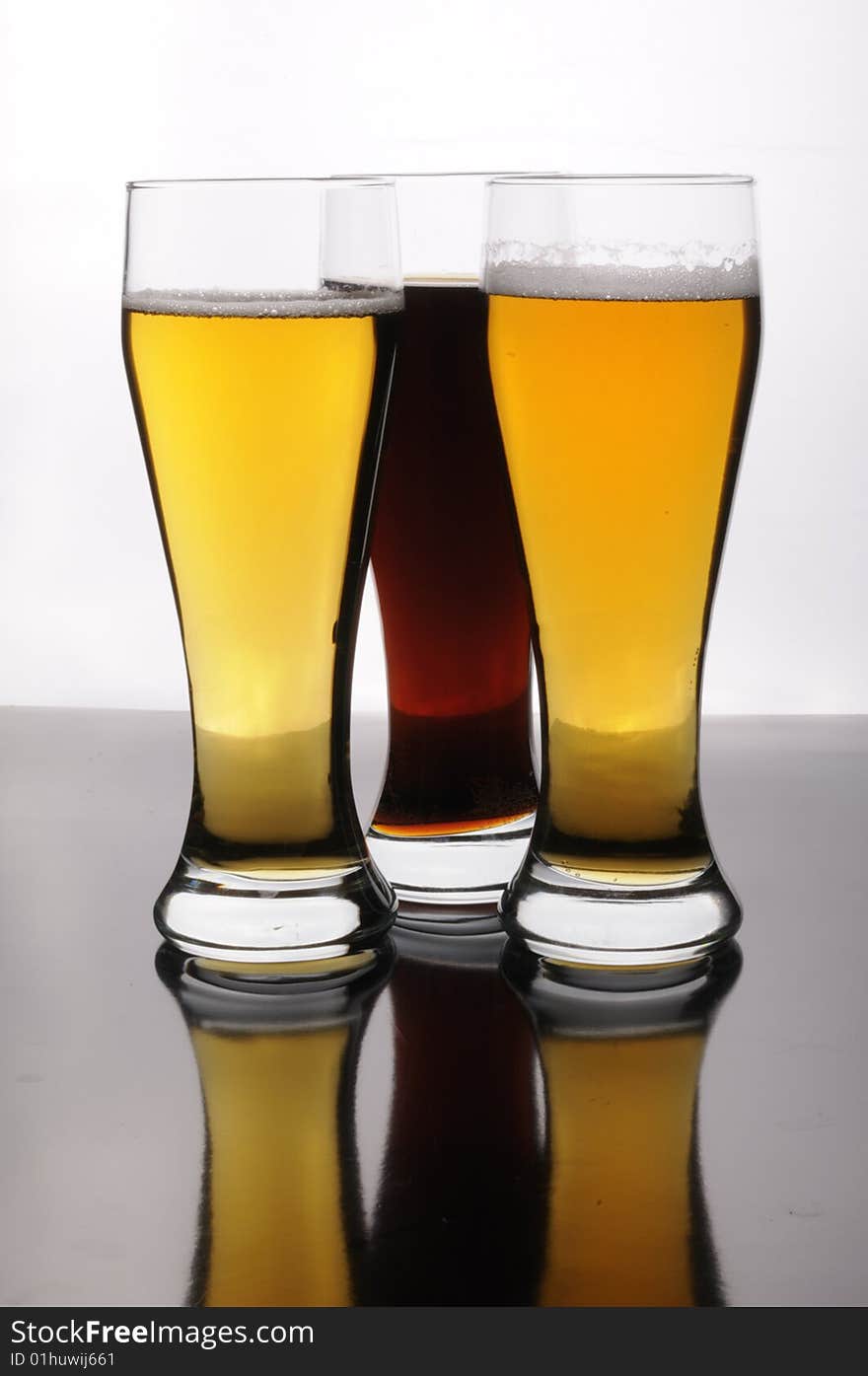 Three glasses of tasty gold and dark beer. Three glasses of tasty gold and dark beer