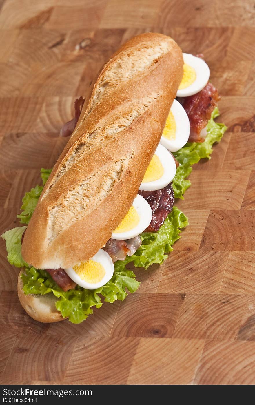 Bacon and egg sandwich on wooden board