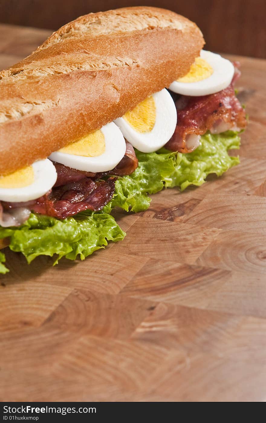 Bacon and egg sandwich on wooden board