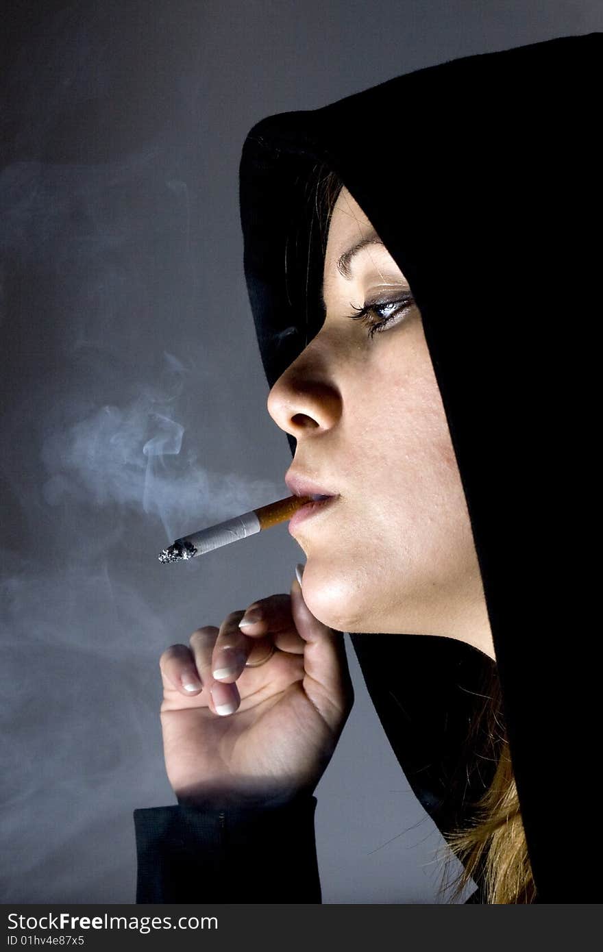 Young attractive girl holding a cigarette in mouth. Young attractive girl holding a cigarette in mouth