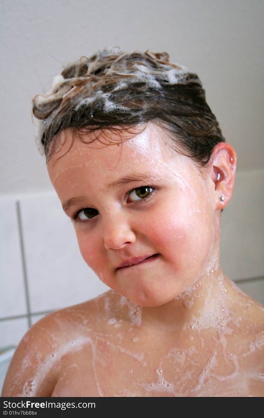 A Child is playing in the bathtub. A Child is playing in the bathtub