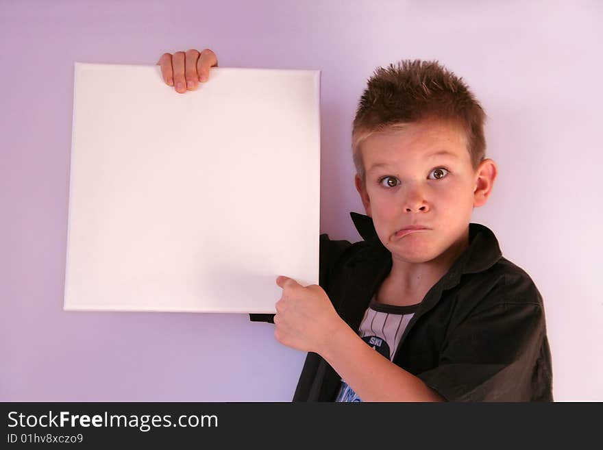 A boy is holding a frame in his hands. A boy is holding a frame in his hands