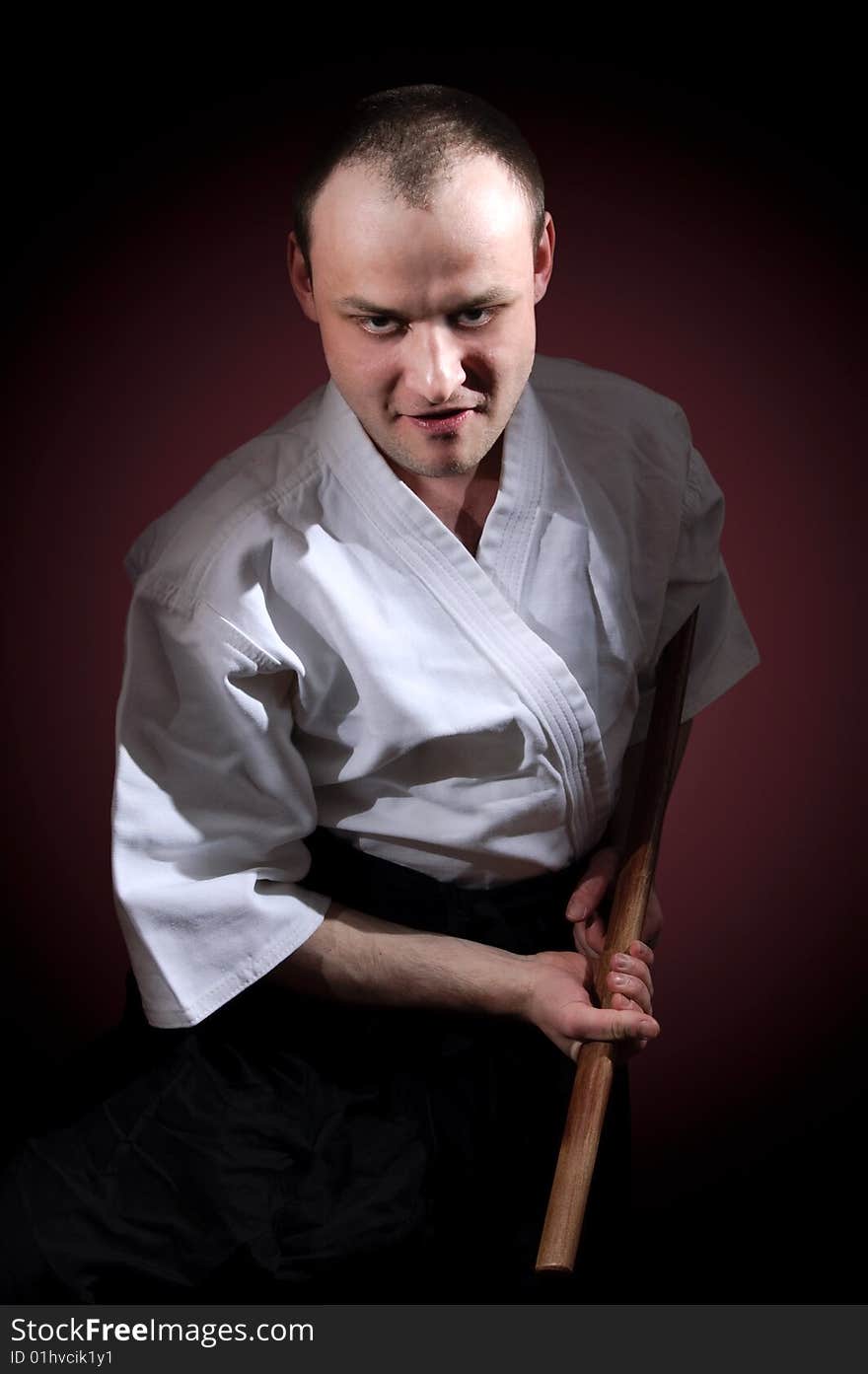 Man in white with wooden sword. Man in white with wooden sword