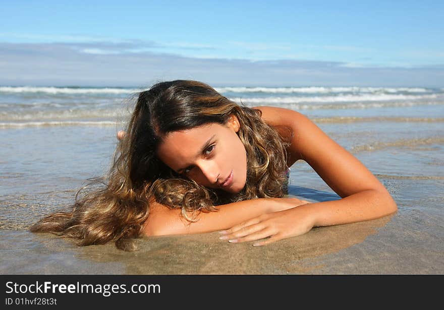 Beautiful woman lays on beach