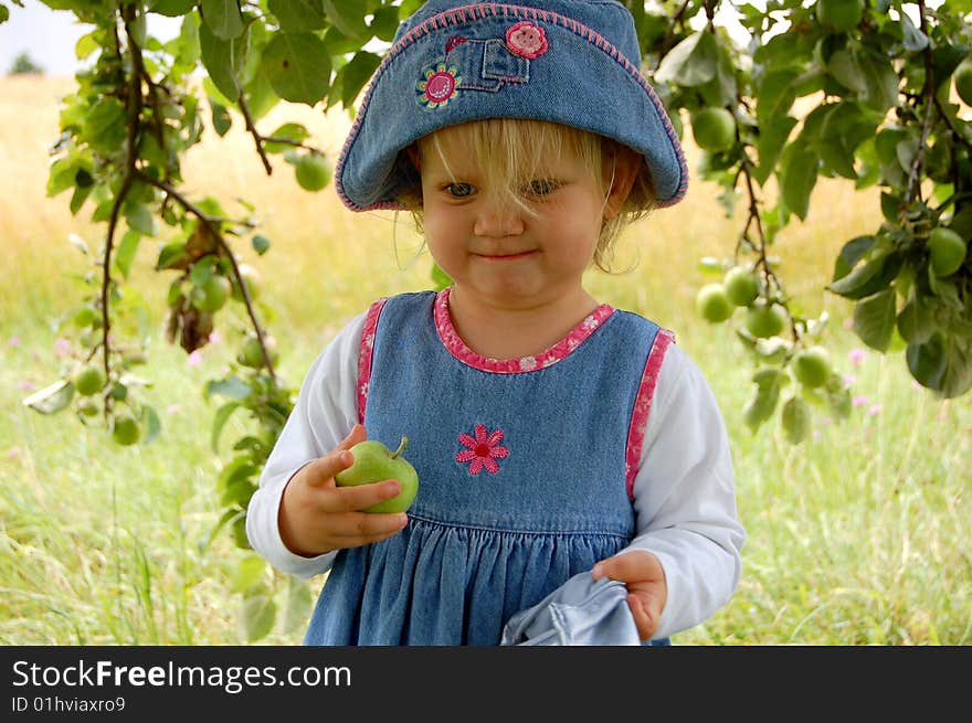 Proud young girl having just picked her first apple ever. Proud young girl having just picked her first apple ever.