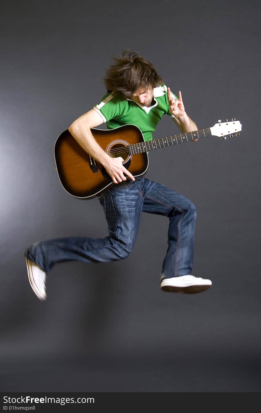 passionate guitarist jumps in the air over black