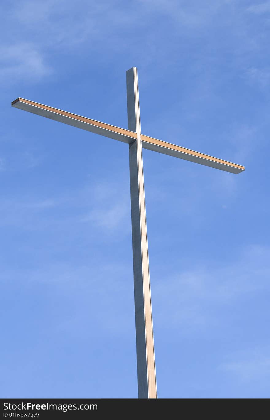 Modern steel cross against blue sky