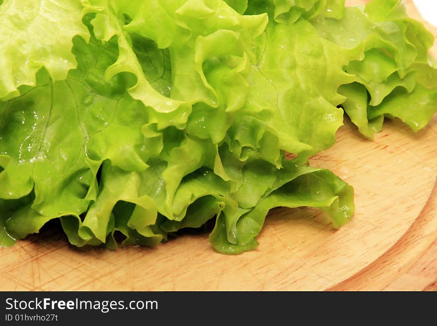 green salad on a wooden plate isolated on a white