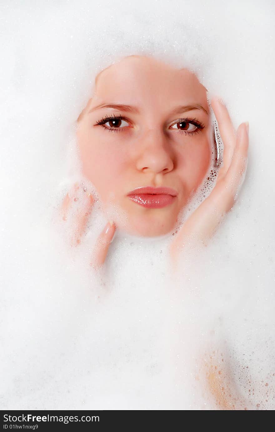 Face of a beautiful woman in white foam. Face of a beautiful woman in white foam