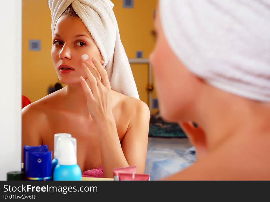 Beauty young woman sitting and looking in the mirror. Beauty young woman sitting and looking in the mirror