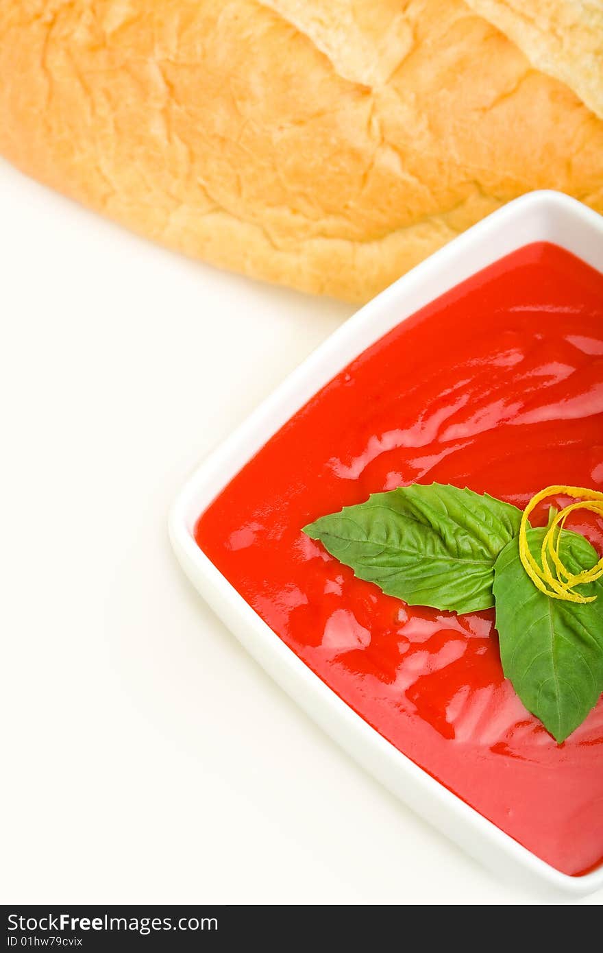 Tomato soup served with basil and bread