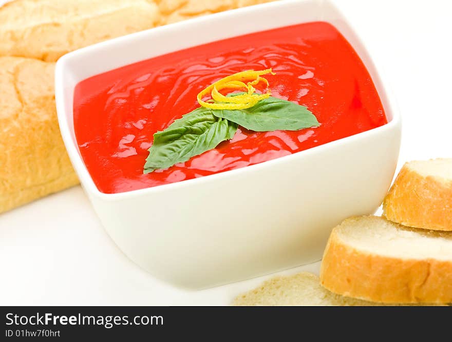 Tomato soup served with basil and bread