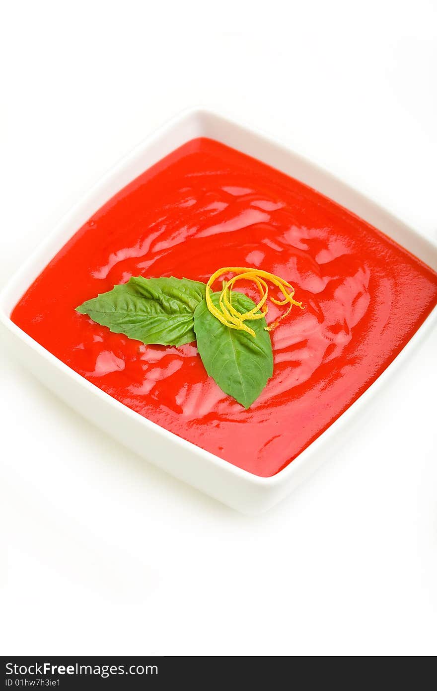 Tomato soup served with basil and bread