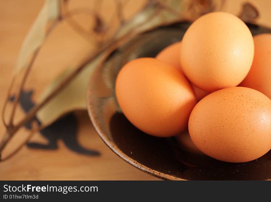 Handmade bowl of fresh australian eggs shown whith a sprig of eucalyptus and kangaroo symbol. Handmade bowl of fresh australian eggs shown whith a sprig of eucalyptus and kangaroo symbol