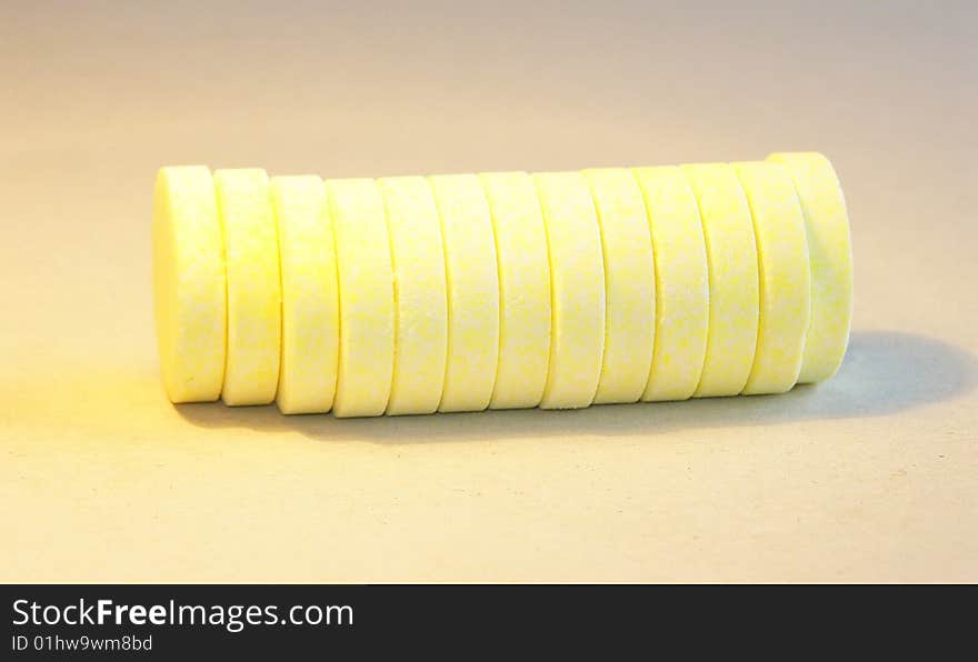 Horizontal stack of yellow effervescent vitamin C tablets, isolated on background. Horizontal stack of yellow effervescent vitamin C tablets, isolated on background