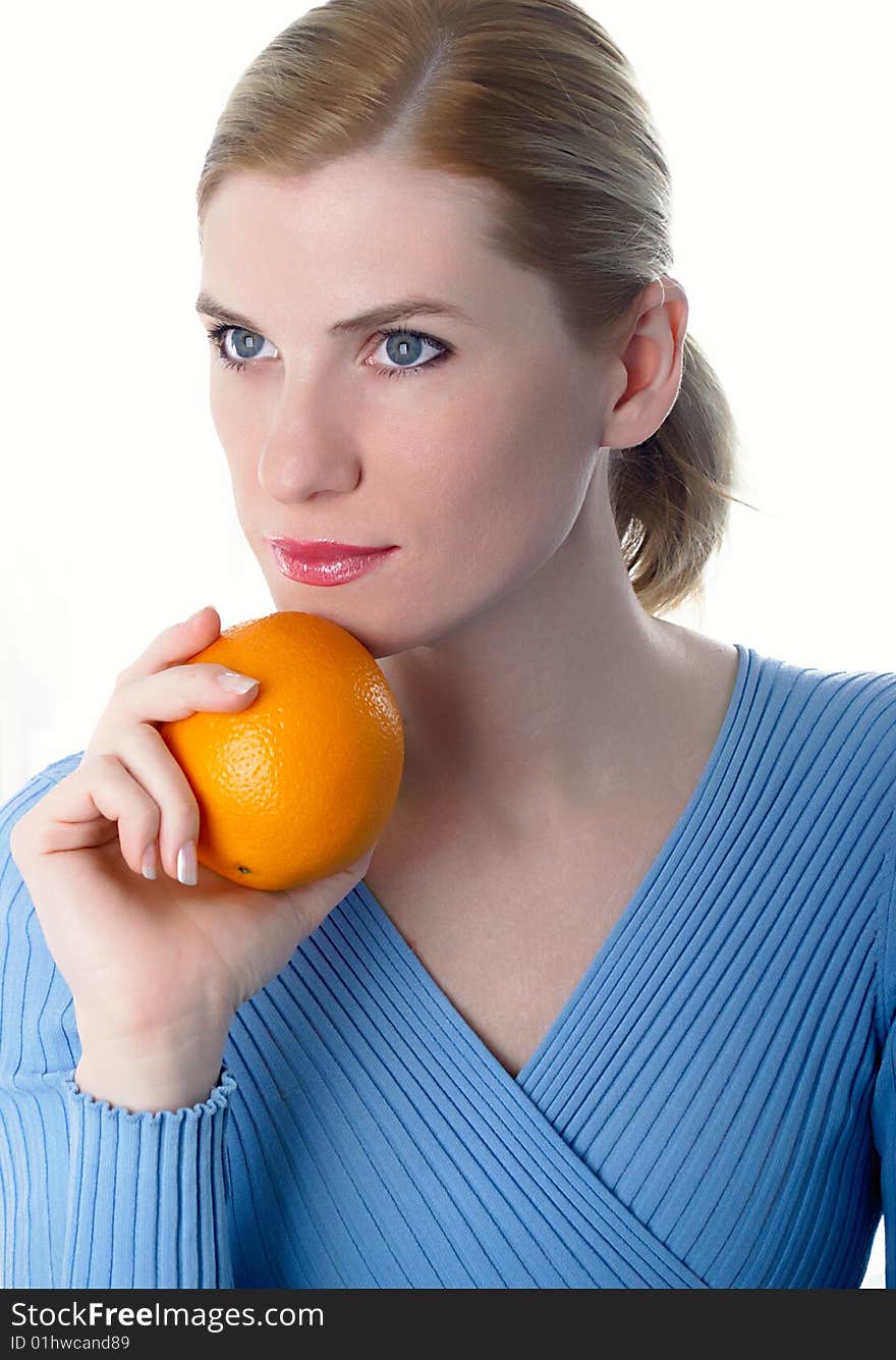 Portrait of the beautiful girl with an orange in hands