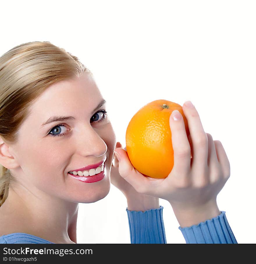 Portrait of the beautiful girl with an orange in hands