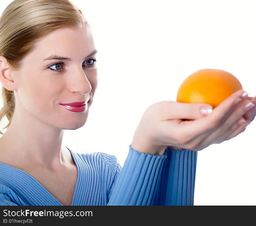 Portrait of the beautiful girl with an orange in hands