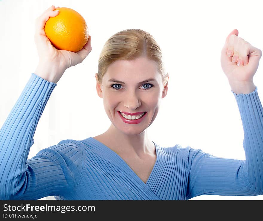 Portrait of the beautiful girl with an orange in hands