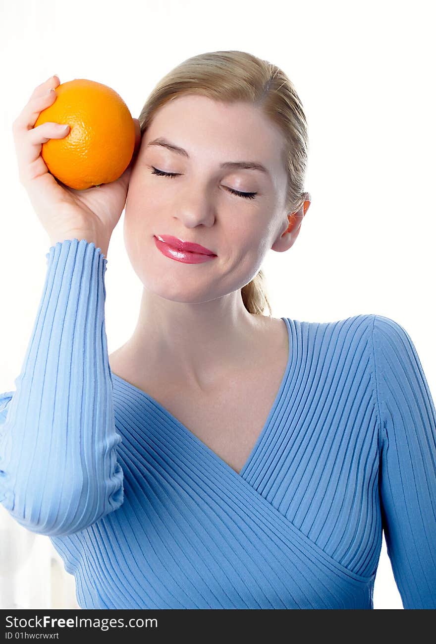 Portrait of the beautiful girl with an orange in hands