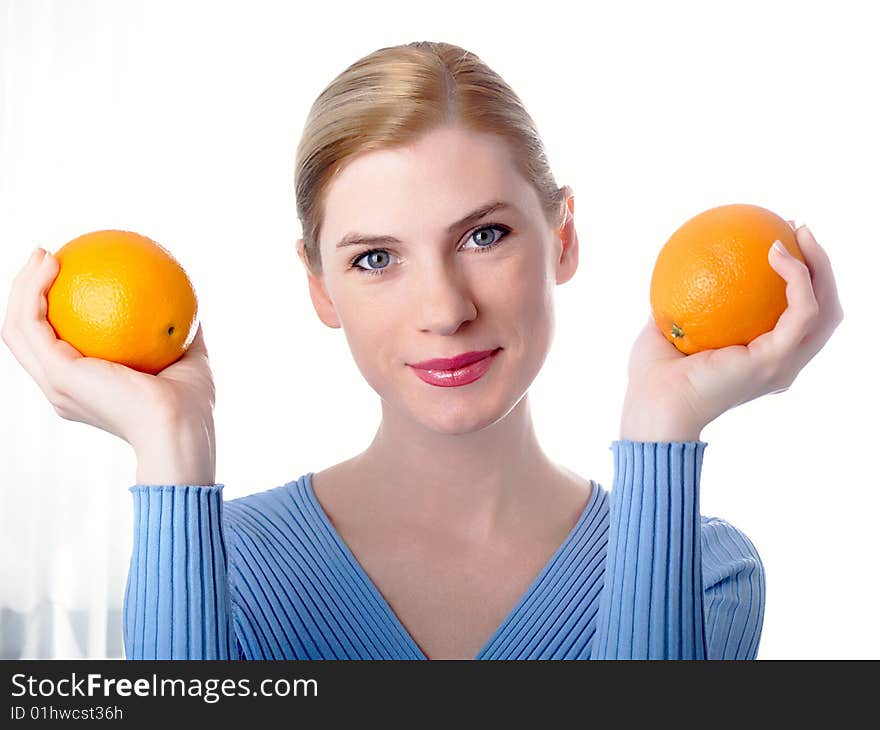 Portrait of the beautiful girl with an orange in hands