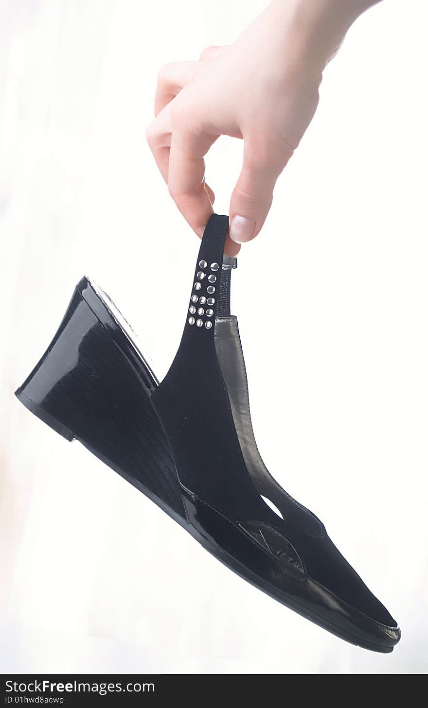 Black shoes in a hand on white background