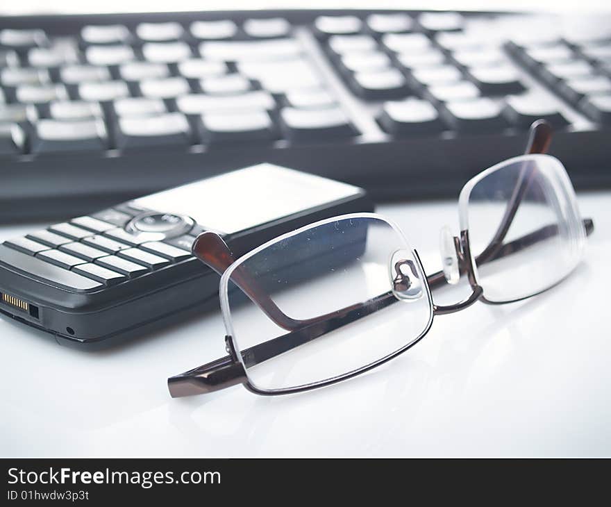 Glasses. mobile phone and keyboard