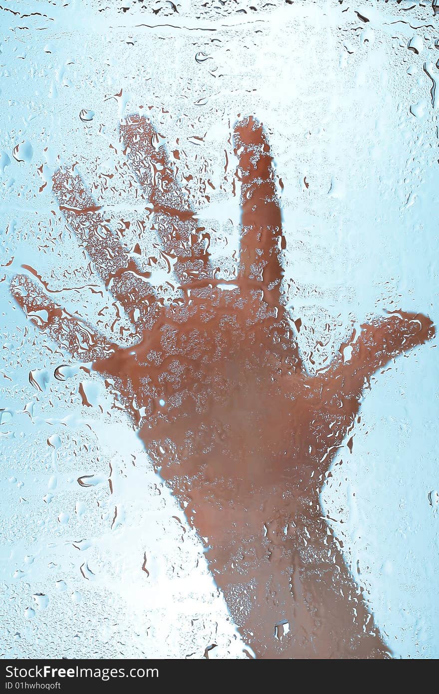 Hand on wet glass surface