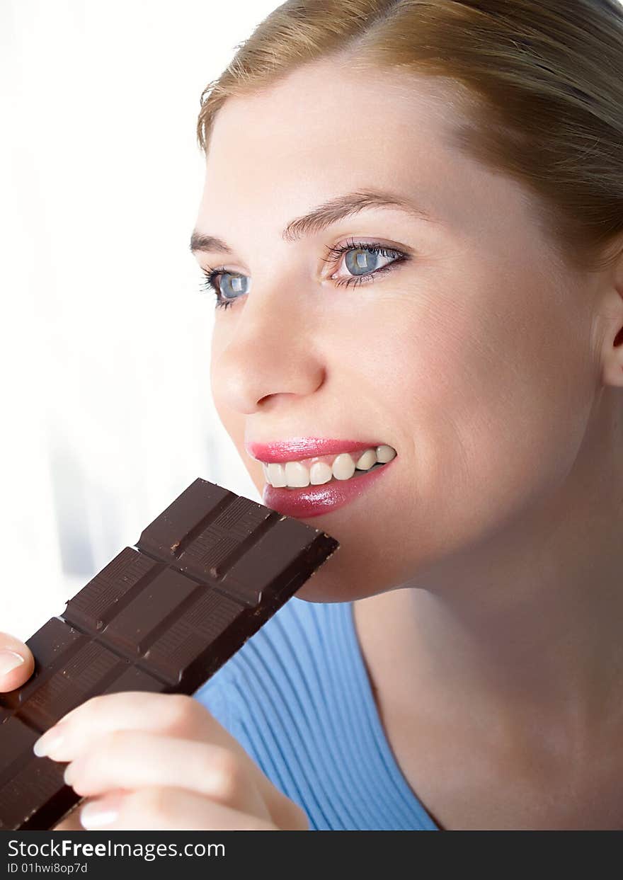 Portrait of the beautiful girl with a chocolate in a hand