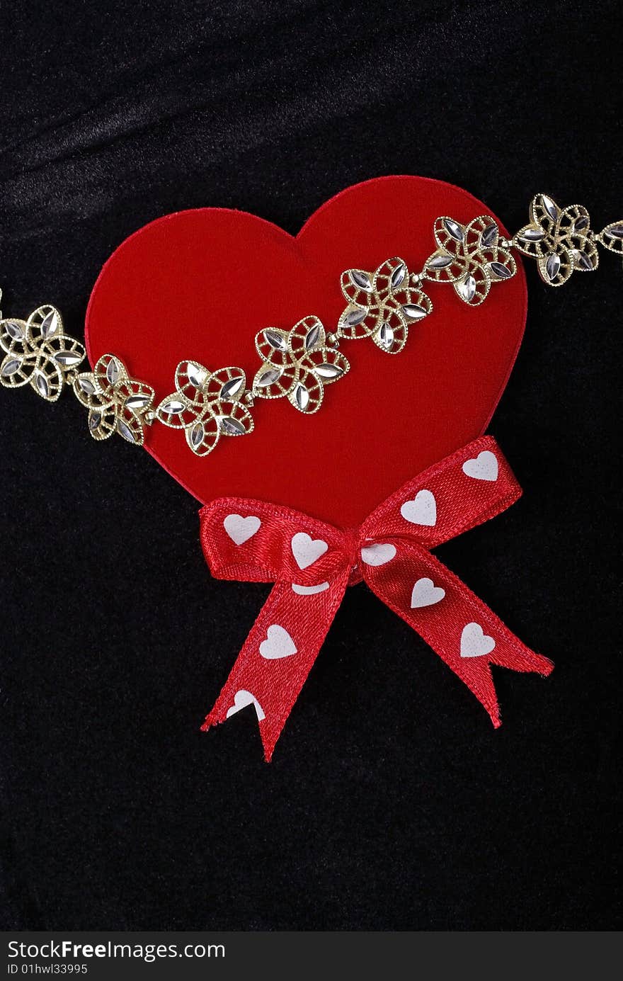 Golden bracelet with red heart