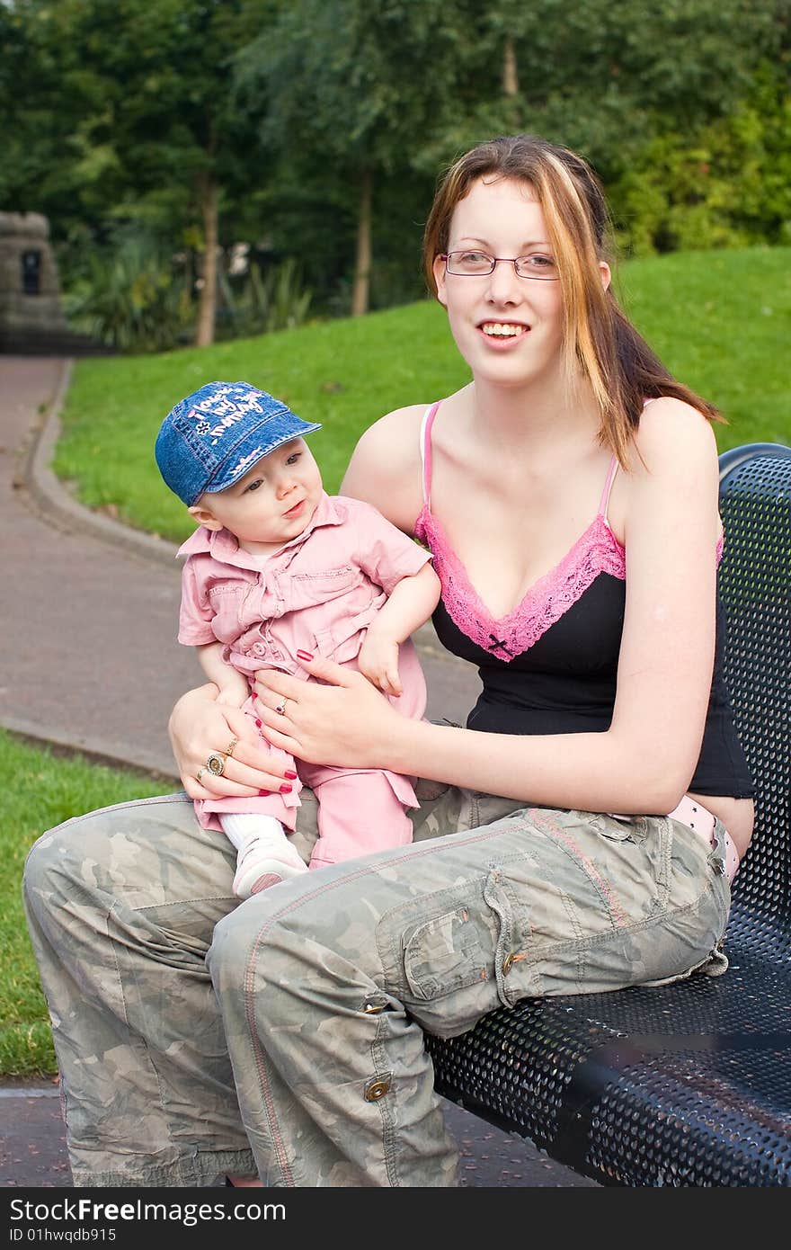 Mother and daughter sitting outside on a park bench