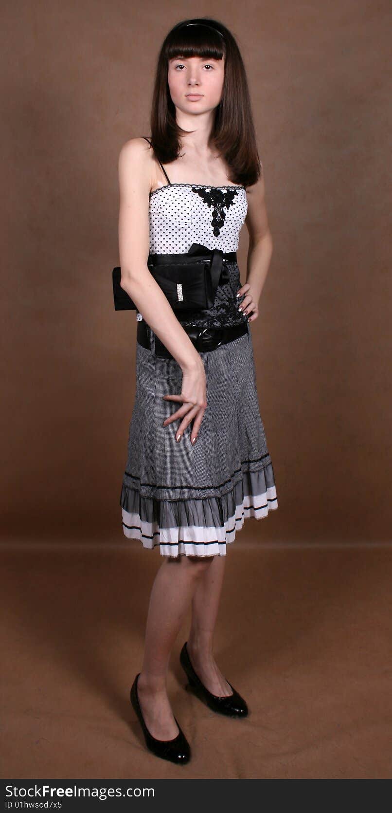 Graceful girl with a bag standing in studio