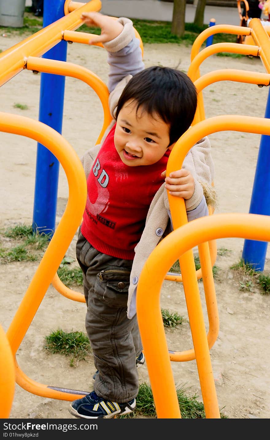 A picture of a little chinese boy walking on a bridge and having great fun. A picture of a little chinese boy walking on a bridge and having great fun