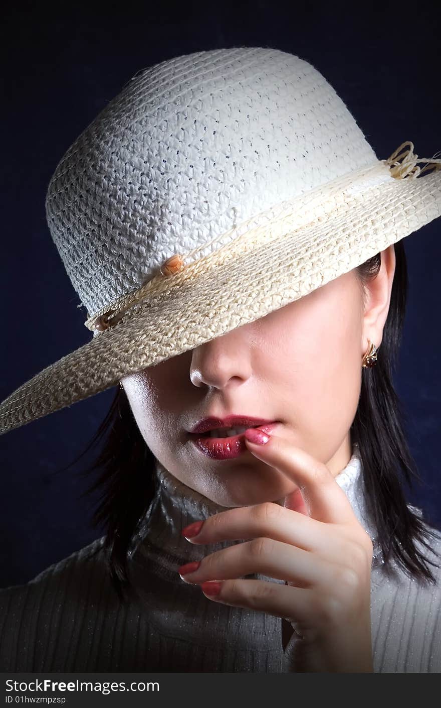 Girl in hat with enigmatic smile on turn blue background. Girl in hat with enigmatic smile on turn blue background