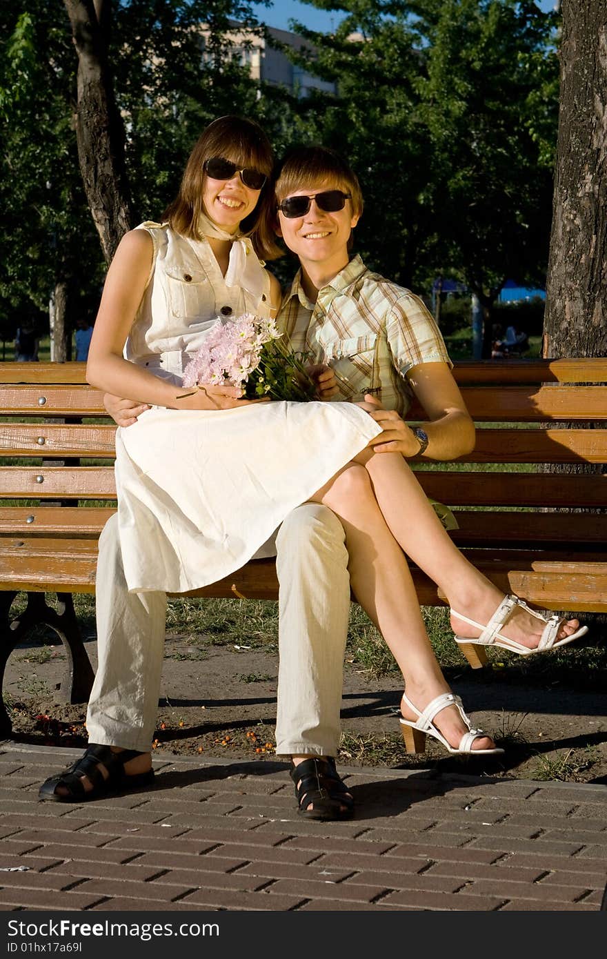 Boy and girl sitting on a bench in a park