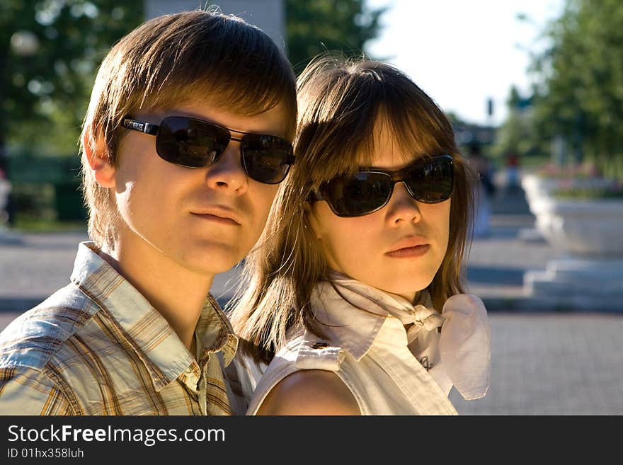 Boy and girl in sunglasses showing how cool they a