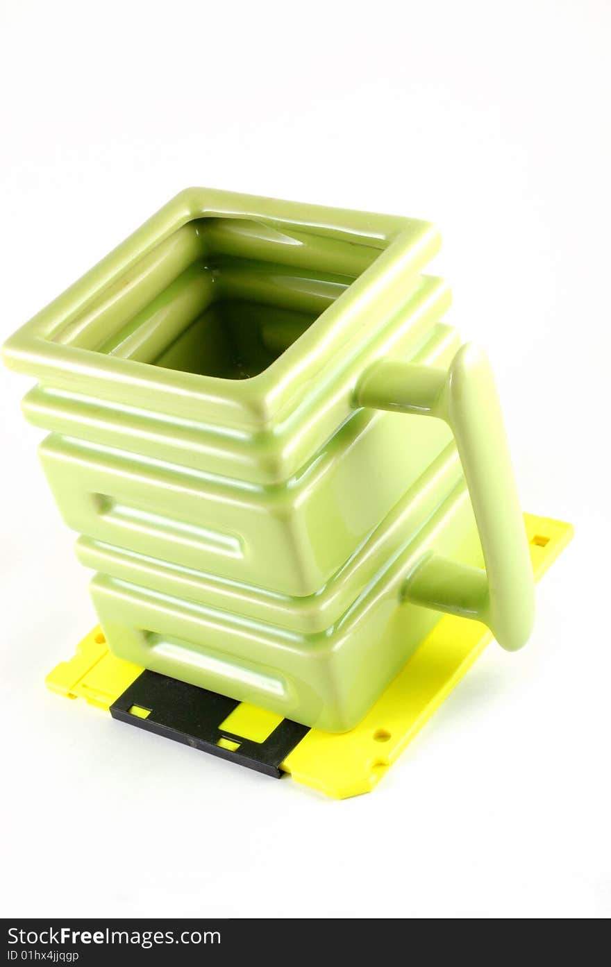 The square mug on a yellow diskette