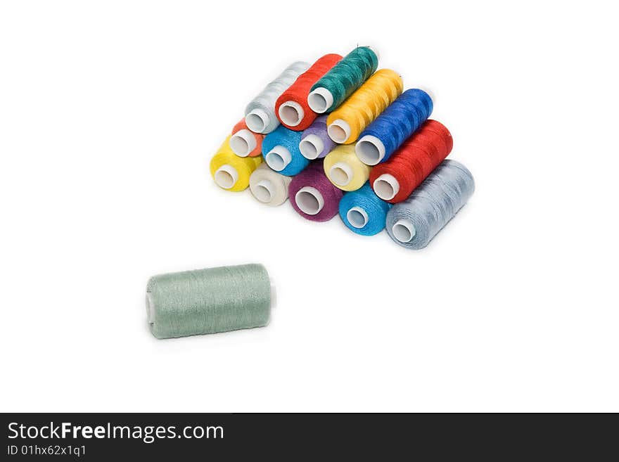 Different colored bobbins on a white background