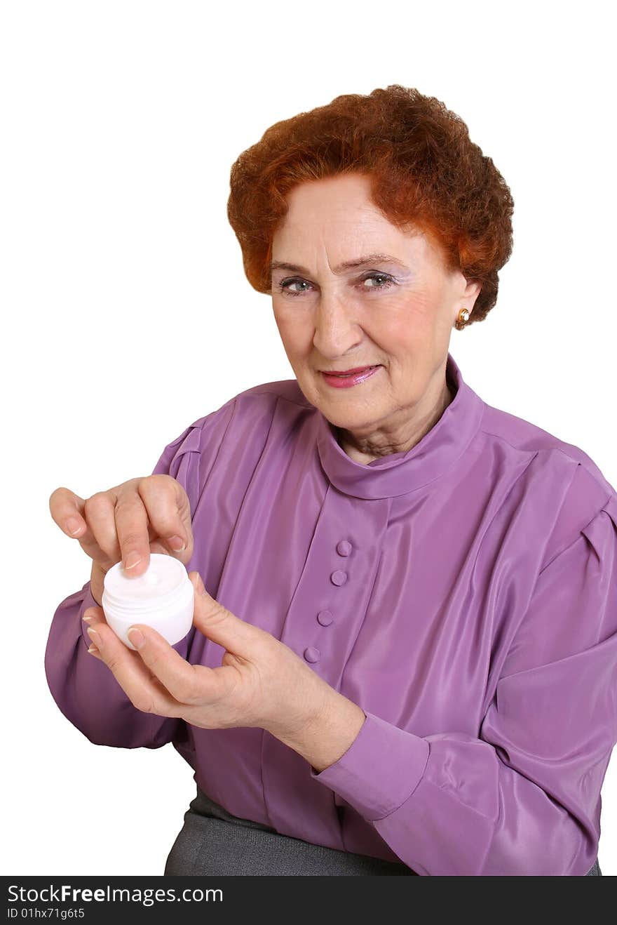 The elderly woman holds in a hand a jar with a cream. The elderly woman holds in a hand a jar with a cream