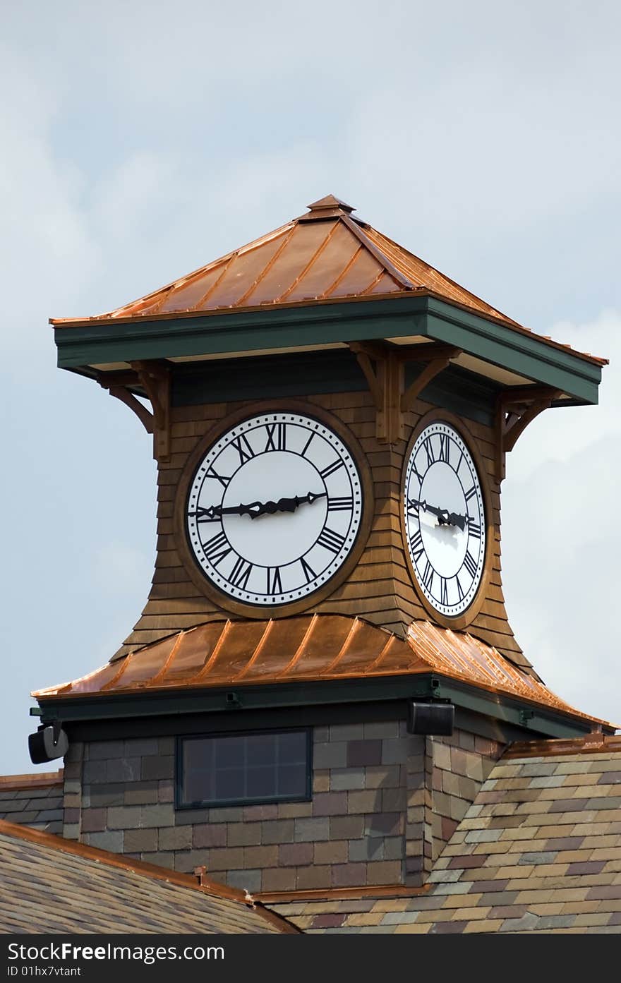 View of a shiny new copper clock tower  on a newly shingled roof.